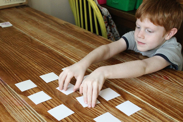 a boy flipping over two cards while playing Concentration